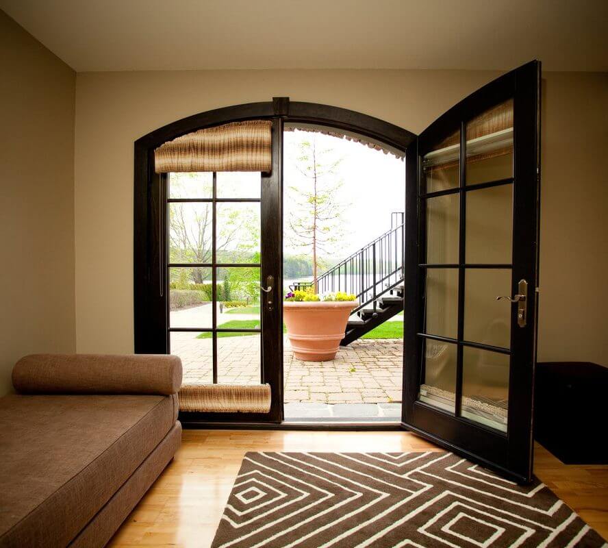 A living room with French doors and a brown rug, staying at the Lake House Inn.
