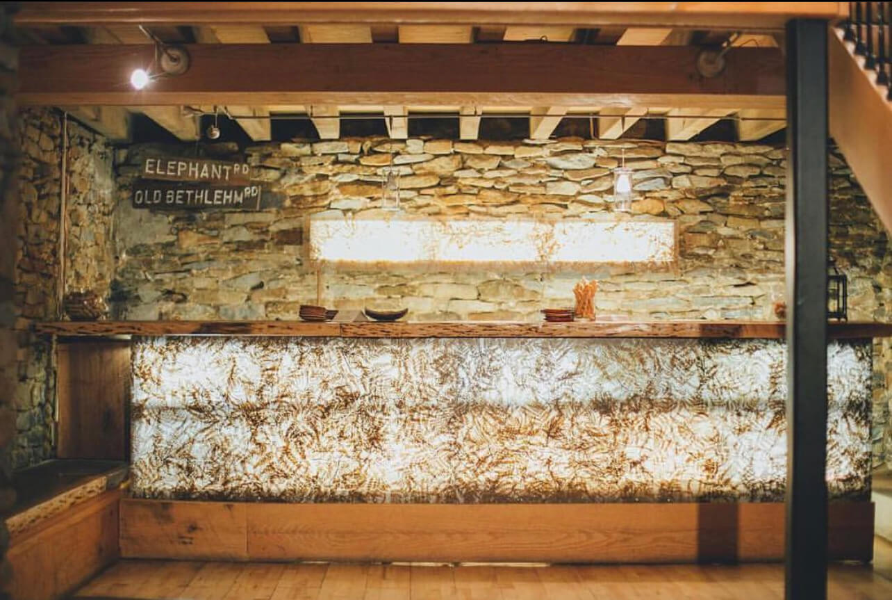 A bar at the lake house inn with a stone wall and wooden steps.