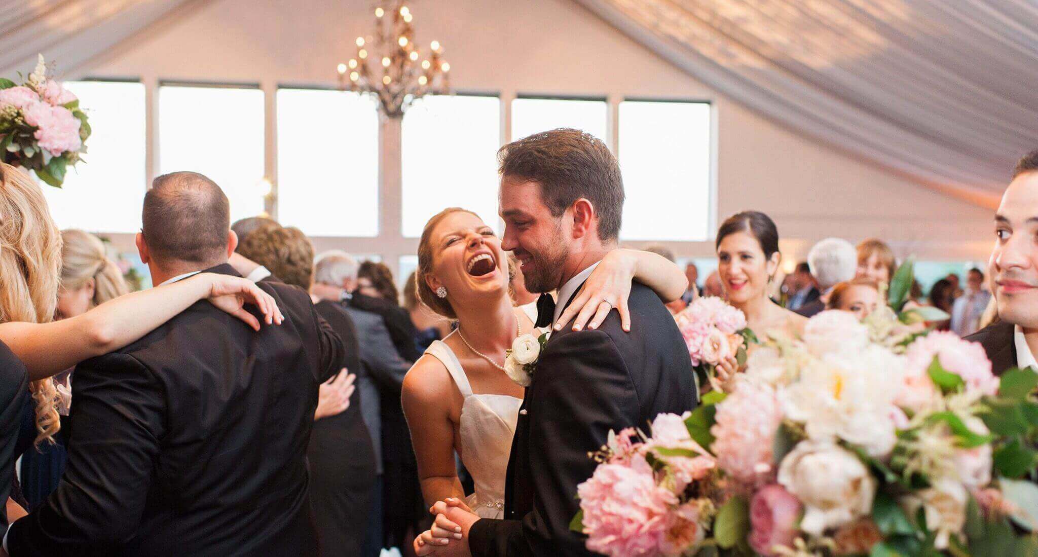 A bride and groom dancing in a wedding tent to enhance their wedding experience.