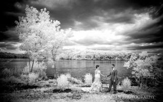 A photo gallery showcasing a bride and groom standing next to a lake in black and white.